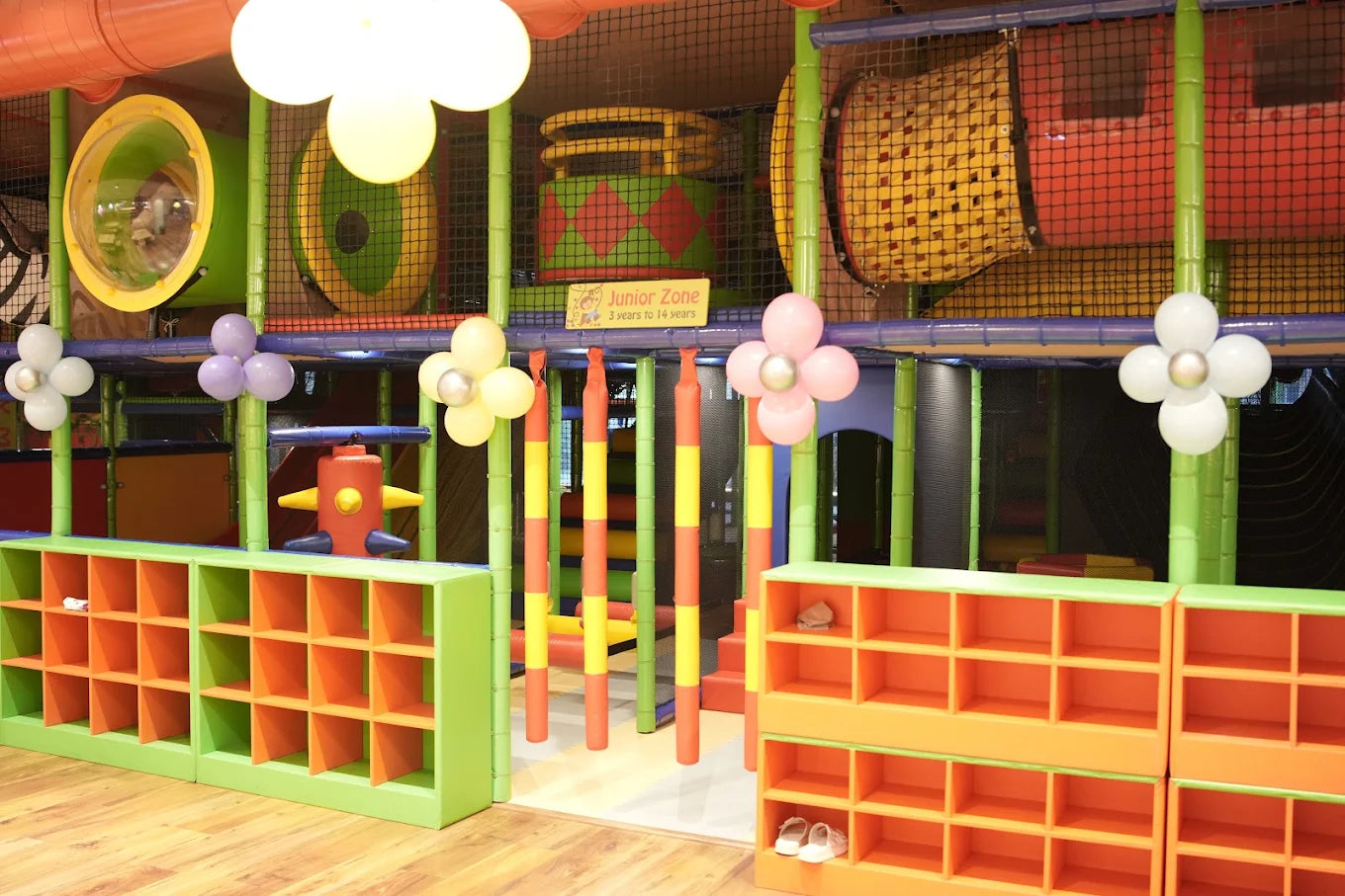 A colorful indoor playground with cubbies and balloons, suitable for young children.