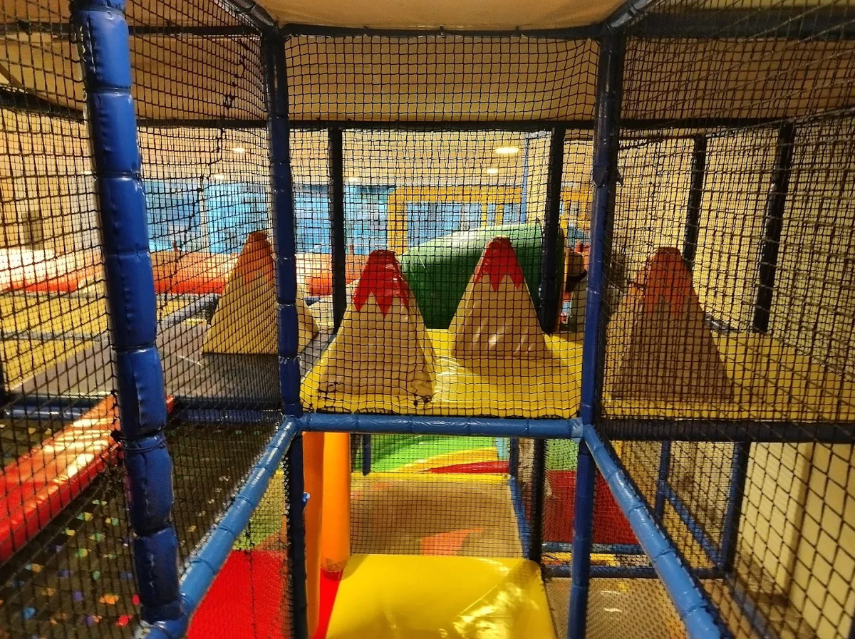 A colorful indoor playground with soft obstacles and climbing structures for young children.