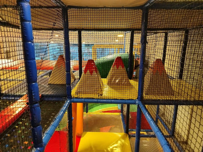 A colorful indoor playground with soft obstacles and climbing structures for young children.