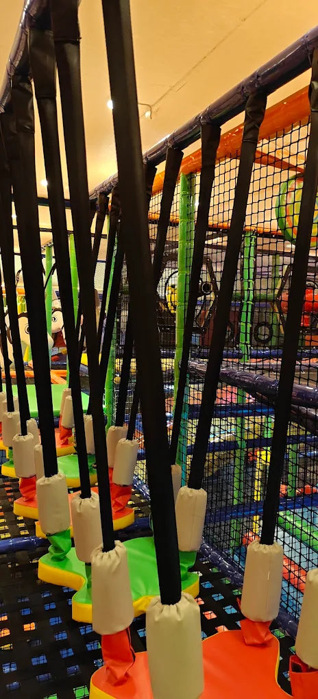 A colorful indoor playground with suspended obstacles for children.