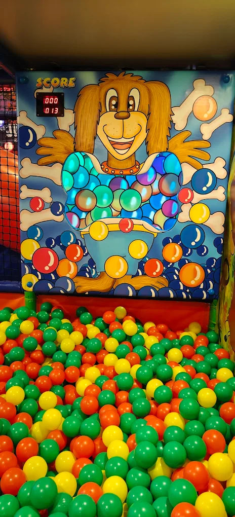 A ball pit with a cartoon dog game and colorful balls.