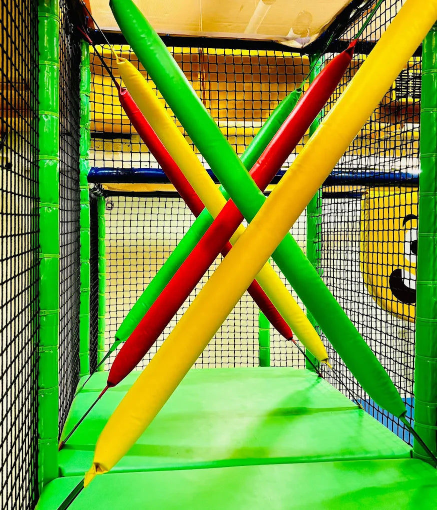 Colorful padded beams crisscross in a children's indoor play area.