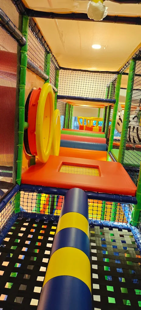 A colorful indoor playground with slides and climbing structures for children.