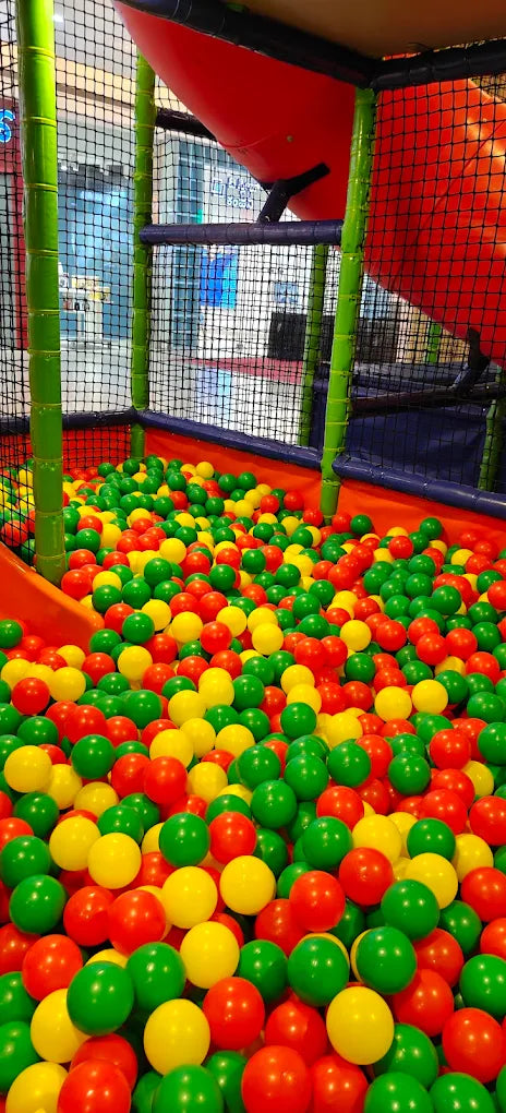 A ball pit filled with red, green, and yellow balls, part of a children's indoor playground.