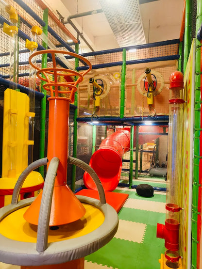A colorful indoor playground with slides, tubes, and interactive elements for children.