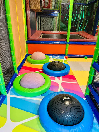 Children's indoor playground with trampolines and inflatable balance balls.