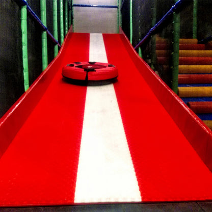 A red and white slide with a red inner tube at a children's play area.