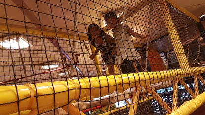 Two children play on a yellow netted playground structure.