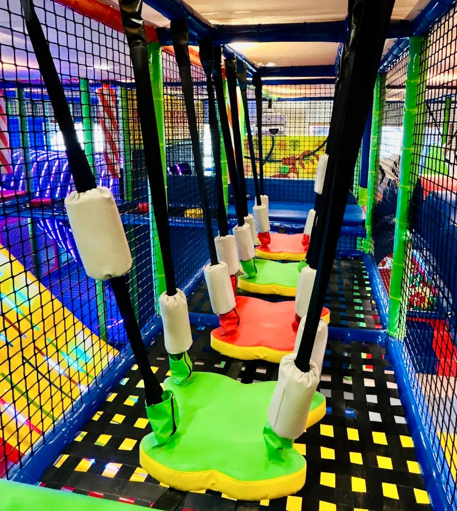 A colorful indoor playground with suspended swings for children.