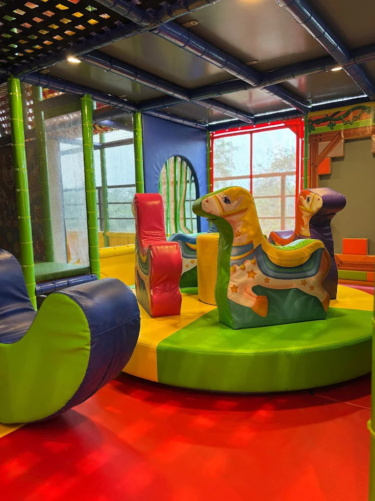 A colorful indoor playground with soft play structures for children.
