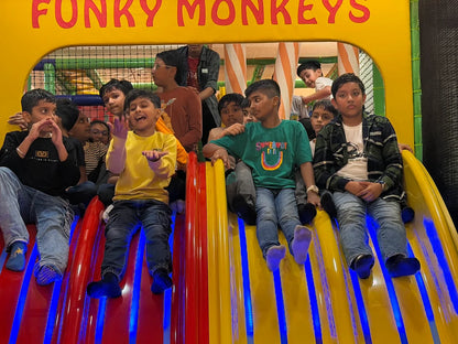 Children on a colorful slide at an indoor playground.