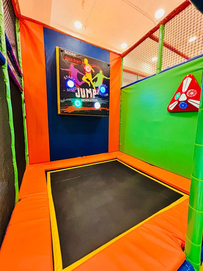 A trampoline with a game screen showing "Jump Revolution" in a colorful indoor play area.