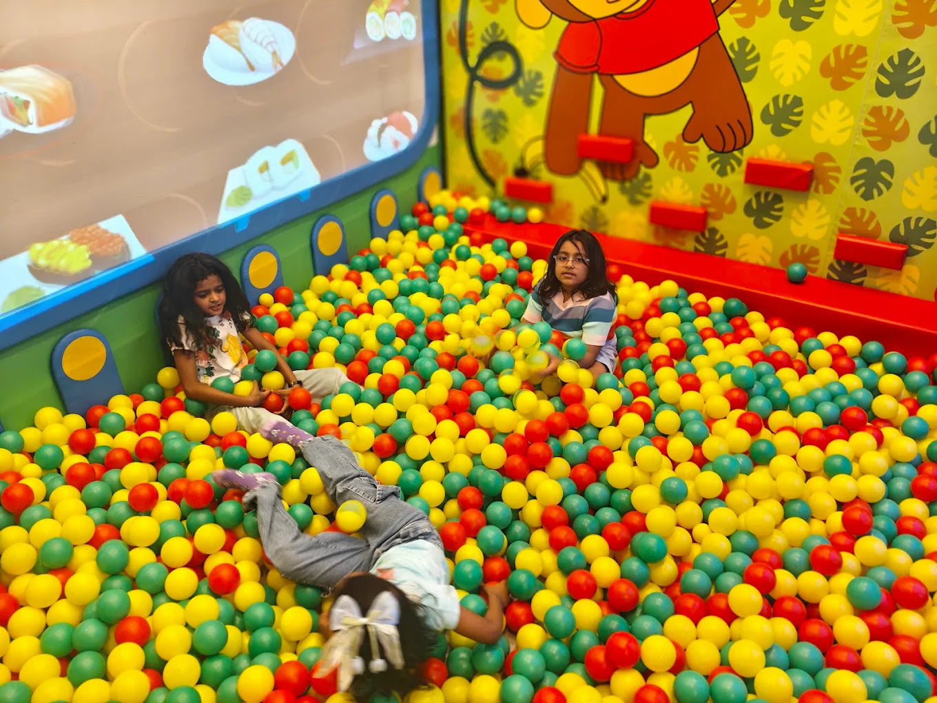 Children play in a ball pit with colorful balls.