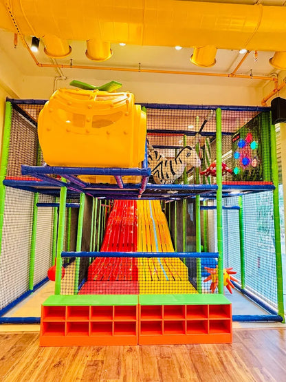 A colorful indoor playground with slides, tunnels, and a yellow helicopter-shaped structure for children.