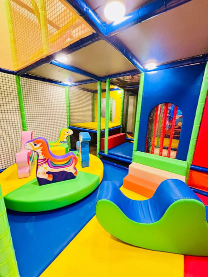 A colorful indoor playground with soft play structures for young children.