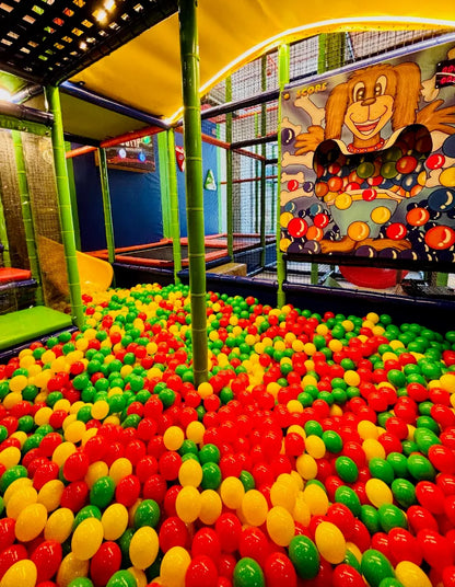A ball pit filled with red, green, and yellow balls, part of a children's indoor playground.