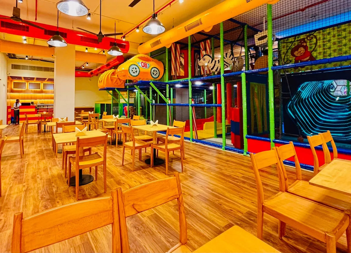 A brightly colored indoor playground with tables and chairs for children.
