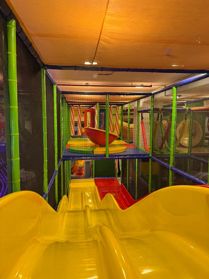 A colorful indoor playground with slides and climbing structures for children.