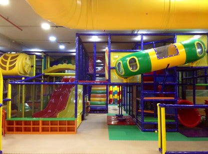 A colorful indoor playground with slides, tunnels, and climbing structures for children.