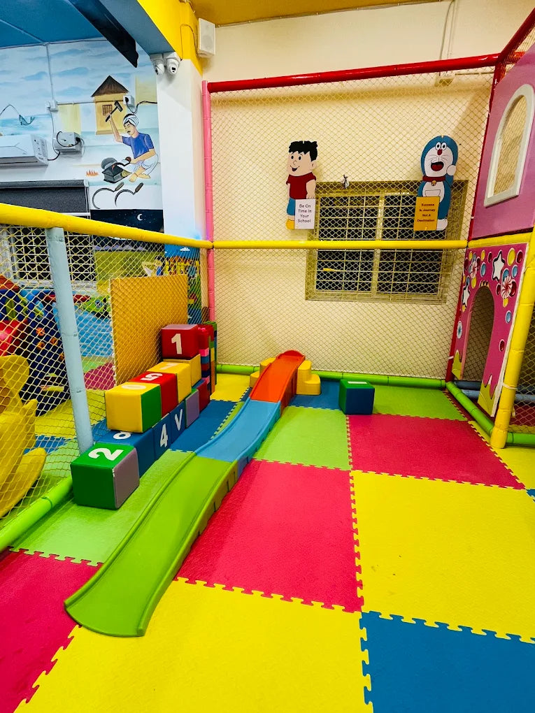 A colorful indoor playground with a slide and soft blocks for young children.