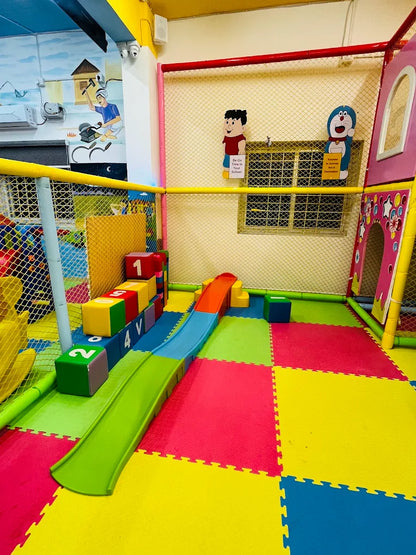 A colorful indoor playground with a slide and soft blocks for young children.