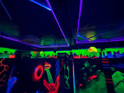 A neon-lit laser tag arena with glowing walls and obstacles.
