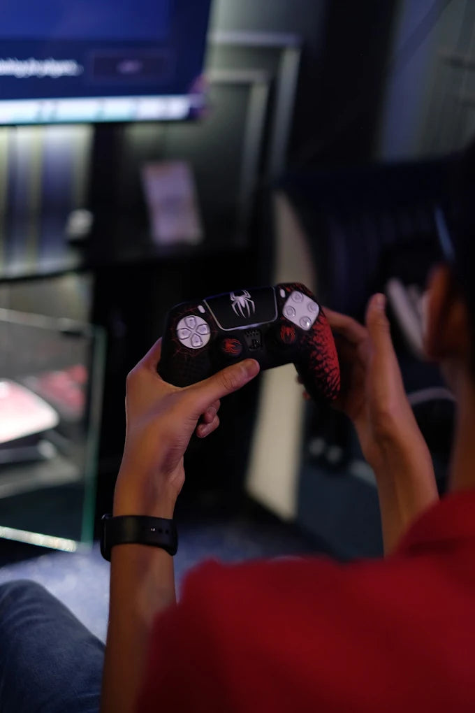 A person holds a Spider-Man themed video game controller, ready to play.
