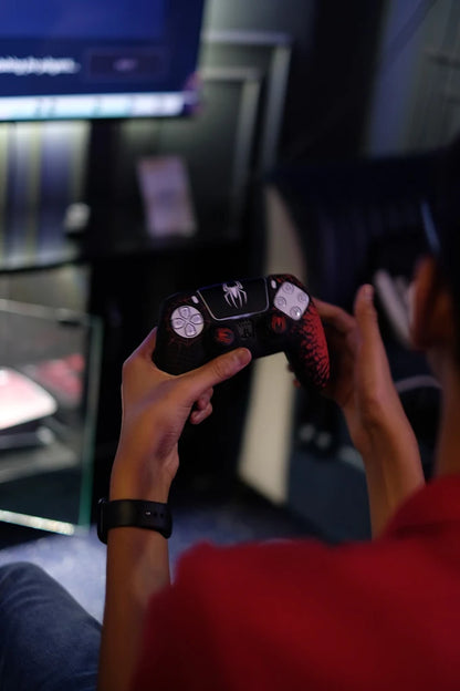 A person holds a Spider-Man themed video game controller, ready to play.