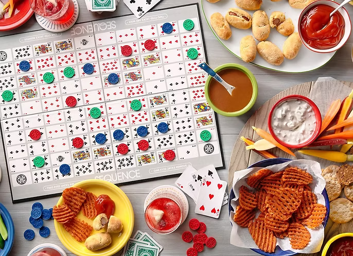A game of Sequence is played with snacks and drinks, suggesting a fun gathering.