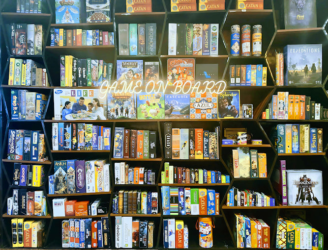 Shelves filled with board game boxes featuring a prominent 'Game On Board' sign.