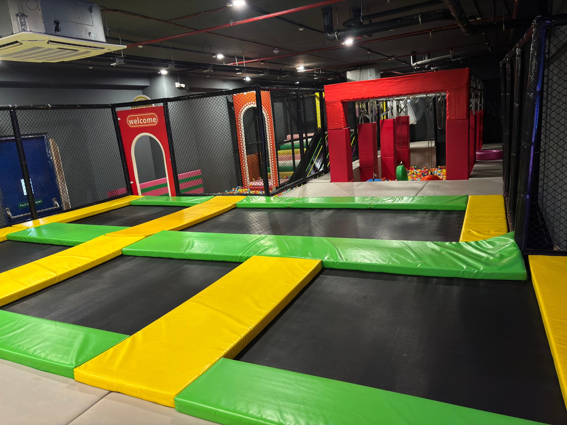Indoor trampoline park with colorful padding and netting.