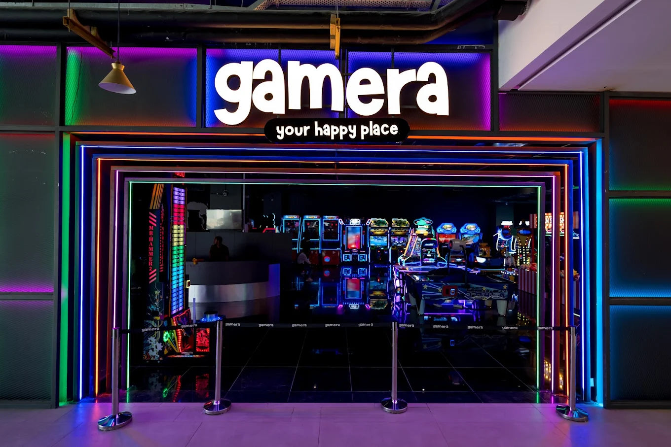 An arcade entrance with neon lights and rows of game machines.