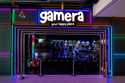 An arcade entrance with neon lights and rows of game machines.