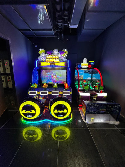 Two brightly lit arcade games, "Raccoon Rampage" and another, stand in a dark arcade.
