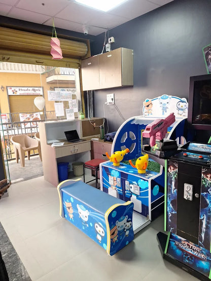 An indoor arcade with children's games and a seating bench.
