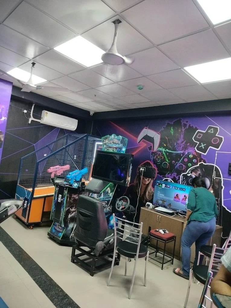 People play video games in an arcade with VR headsets and racing simulators.