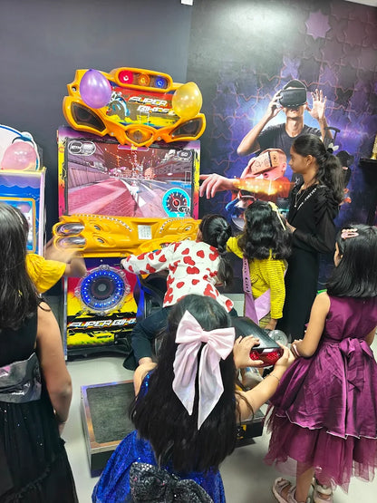 Children play a motorcycle arcade game at an entertainment center.