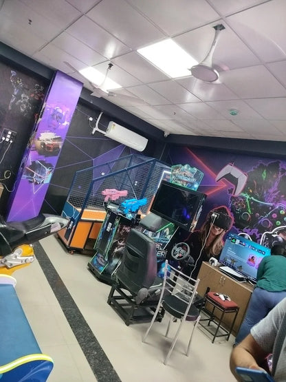 People play VR games and arcade games in a brightly lit entertainment center.