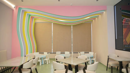 A brightly colored, modern cafe with small tables and chairs, likely for children.