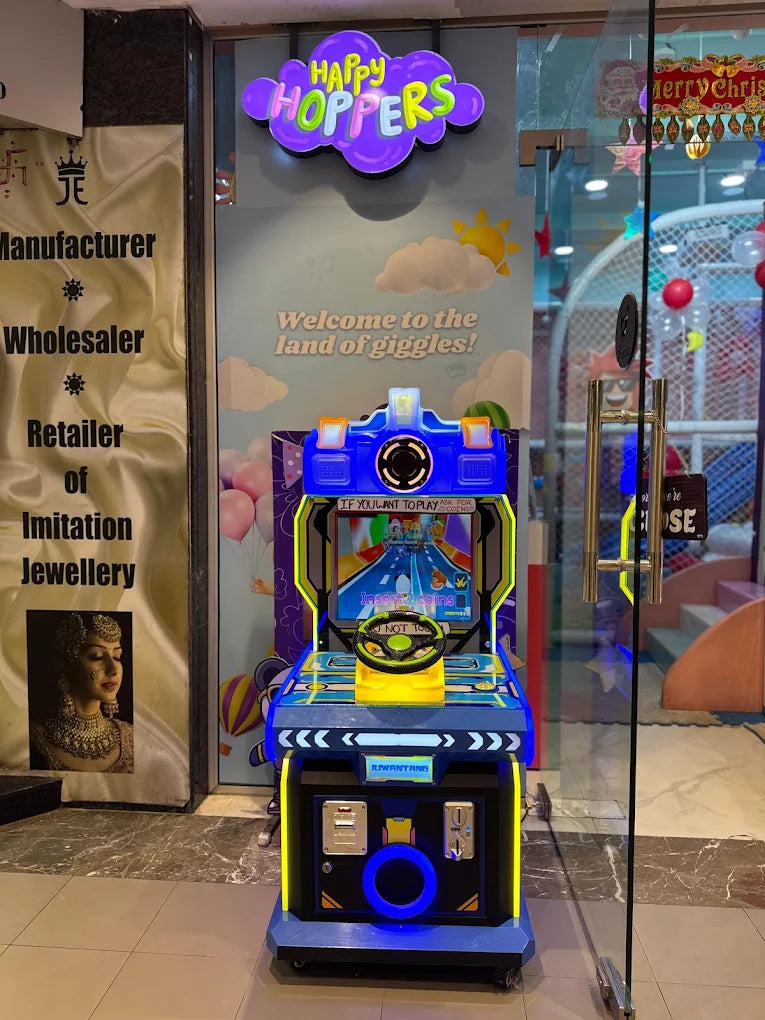 A colorful arcade racing game is set up in front of a store with a "Happy Hoppers" sign.