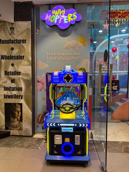 A colorful arcade racing game is set up in front of a store with a "Happy Hoppers" sign.