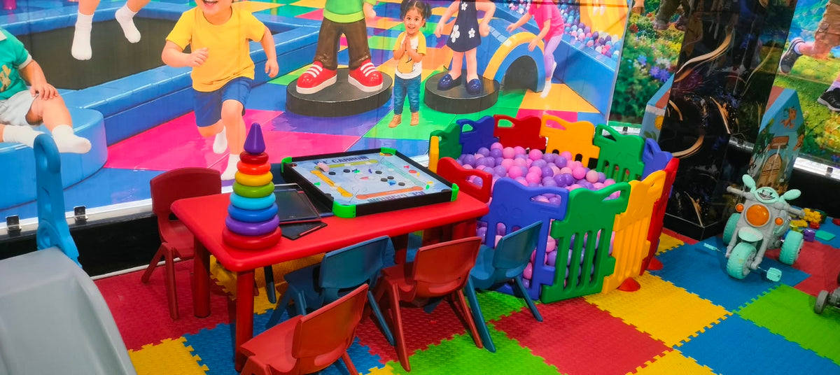 Children's play area with a ball pit, carrom board, and toys.