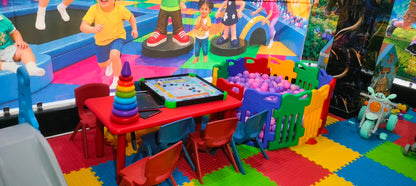 Children's play area with a ball pit, carrom board, and toys.