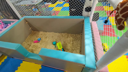 A sandpit with toys in a children's play area.