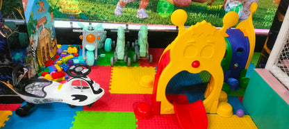 A colorful indoor play area with toys and a slide for young children.