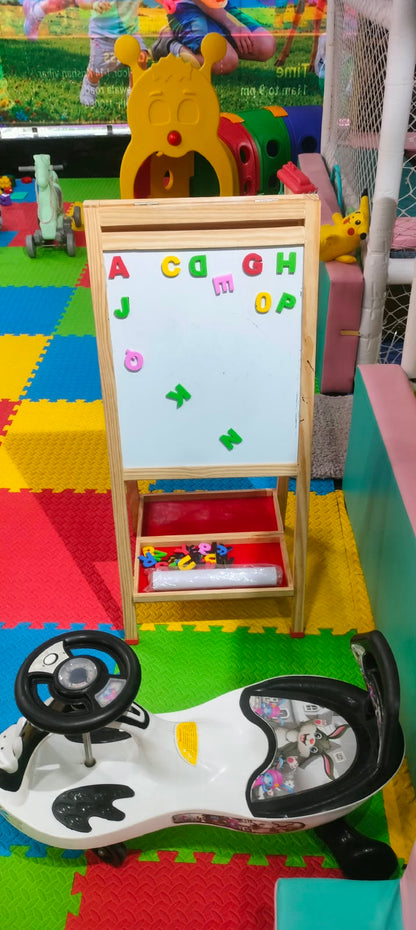 A child's play area with a whiteboard, toy car, and colorful floor mats.