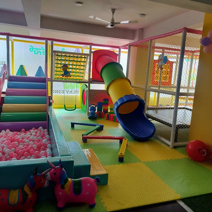 A colorful indoor playground with slides, ball pit, and climbing structures for young children.