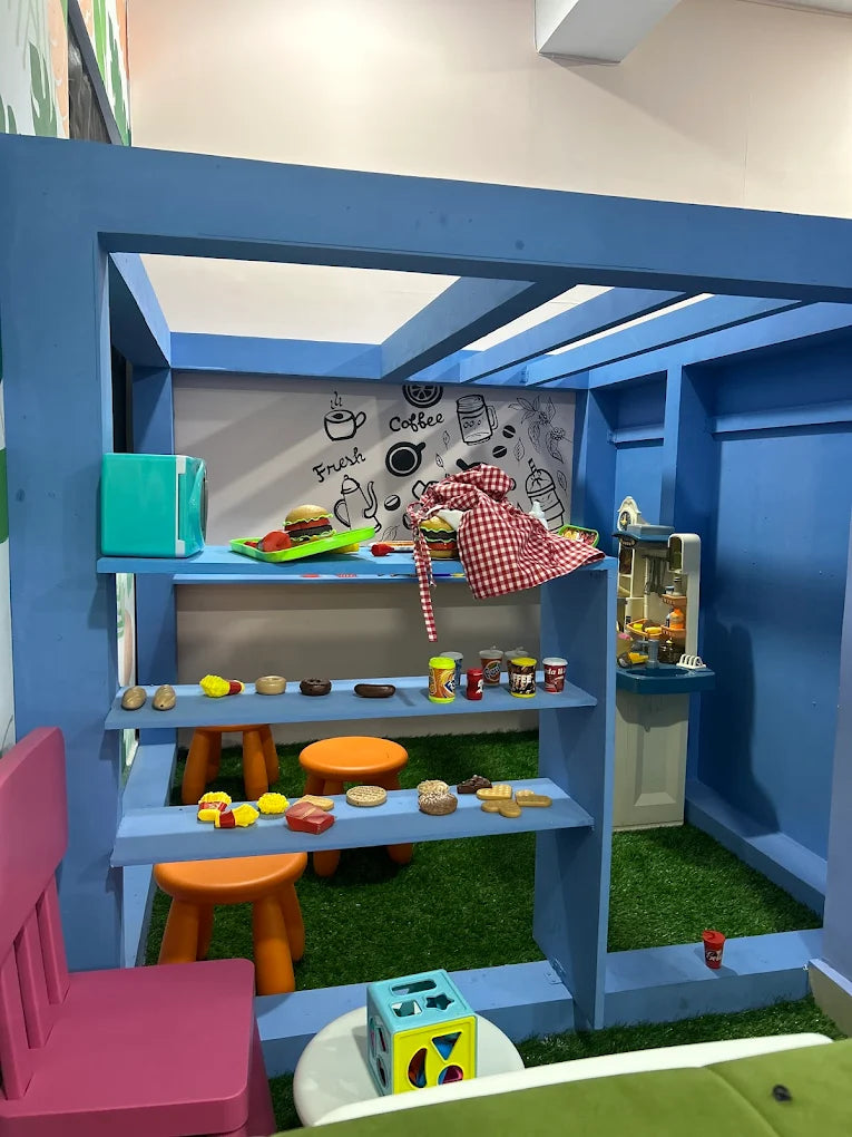 A child's play kitchen with toy food and accessories.