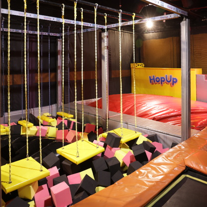 A foam pit with hanging swings at an indoor trampoline park.
