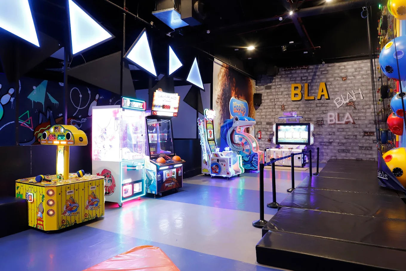 An arcade with various games and a climbing wall.